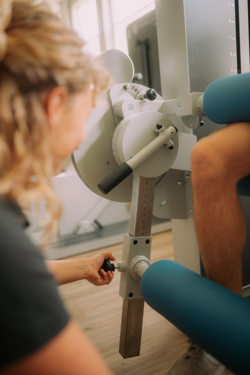 Patient bei krankengymnastische Rückenübung auf Gerät liegend