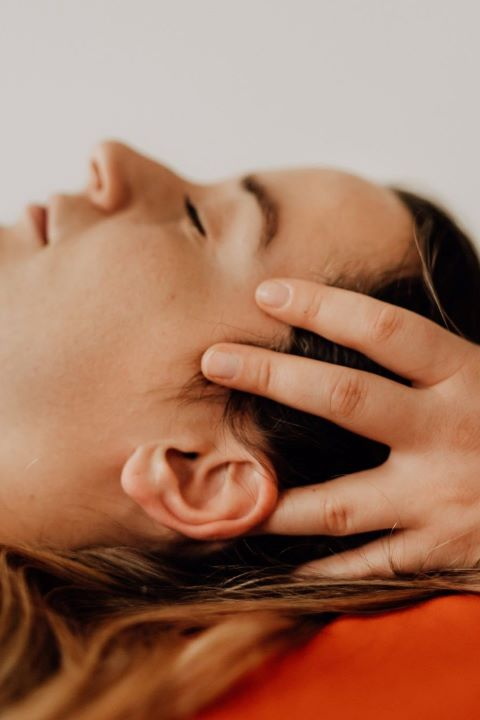 Osteopathische Behandlung am Kopf einer Patientin